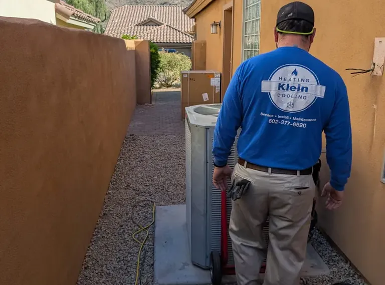 Klein technician walking to a condenser in a side yard in Scottsdale, AZ