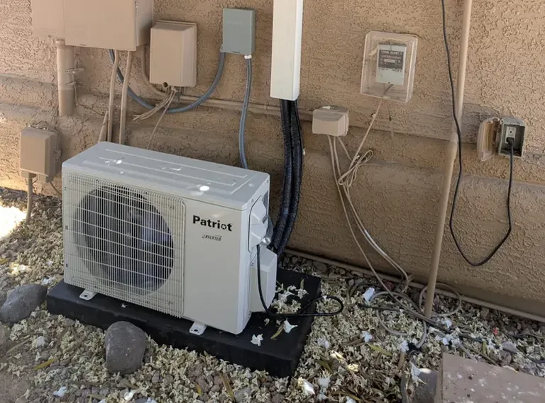 Ductless mini-split outdoor unit installed against a stucco wall in Gilbert, AZ