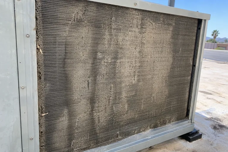 Dirt-clogged rooftop condenser coil before cleaning in Peoria, AZ